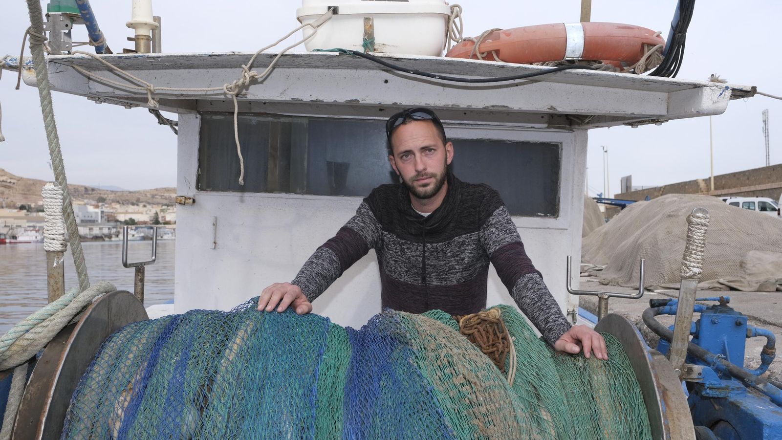 Cristo, ante las redes de una embarcación en el Puerto de Almería.