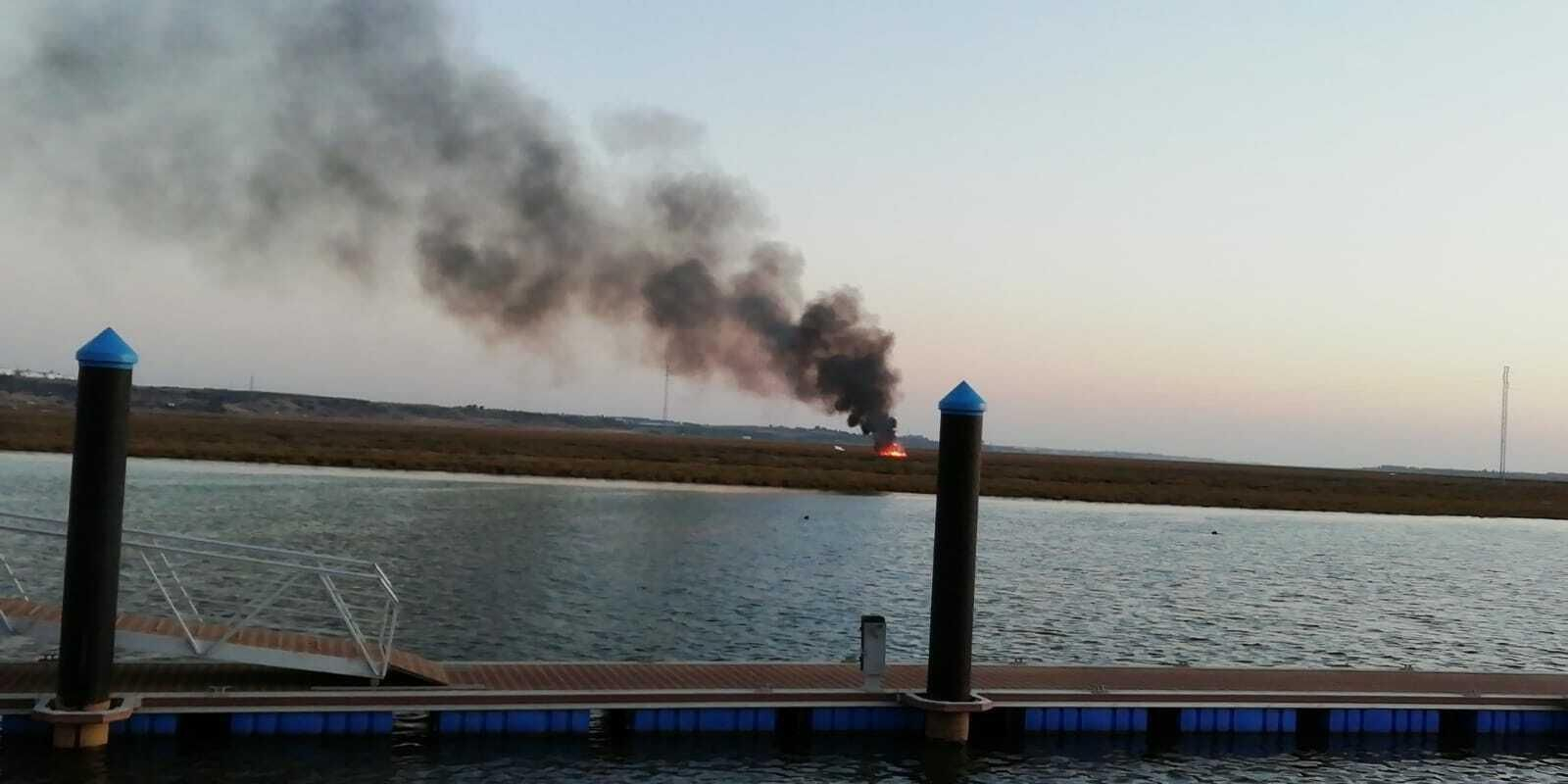 La avioneta en llamas vista desde el muelle de San Juan del Puerto.