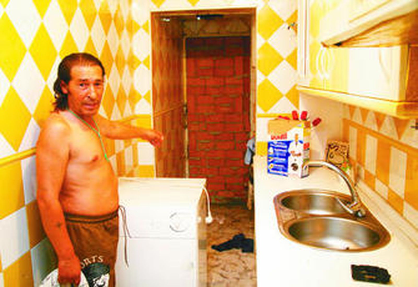 Ángel Jiménez muestra la tapia que la Junta levantó en su cocina, que está desvalijada.