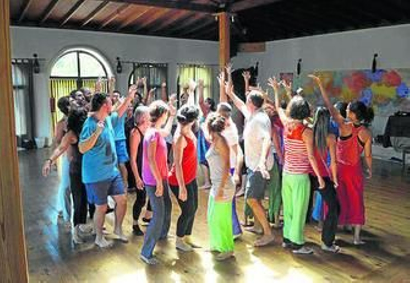 Un grupo de personas realizan un taller de danza.