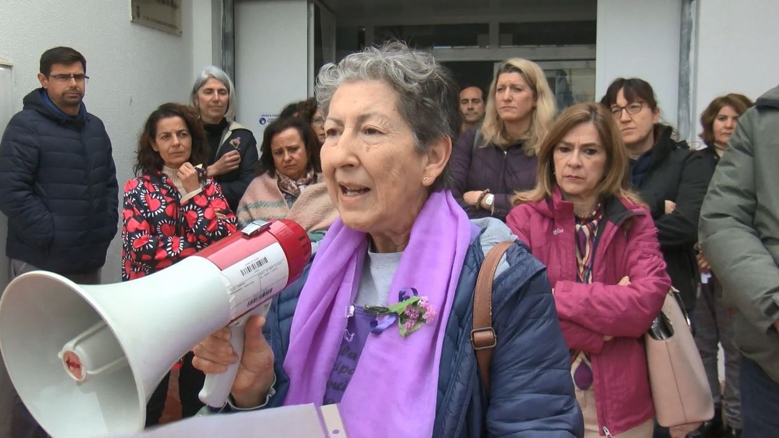 Una participante toma la palabra ante la sede de Servicios Sociales