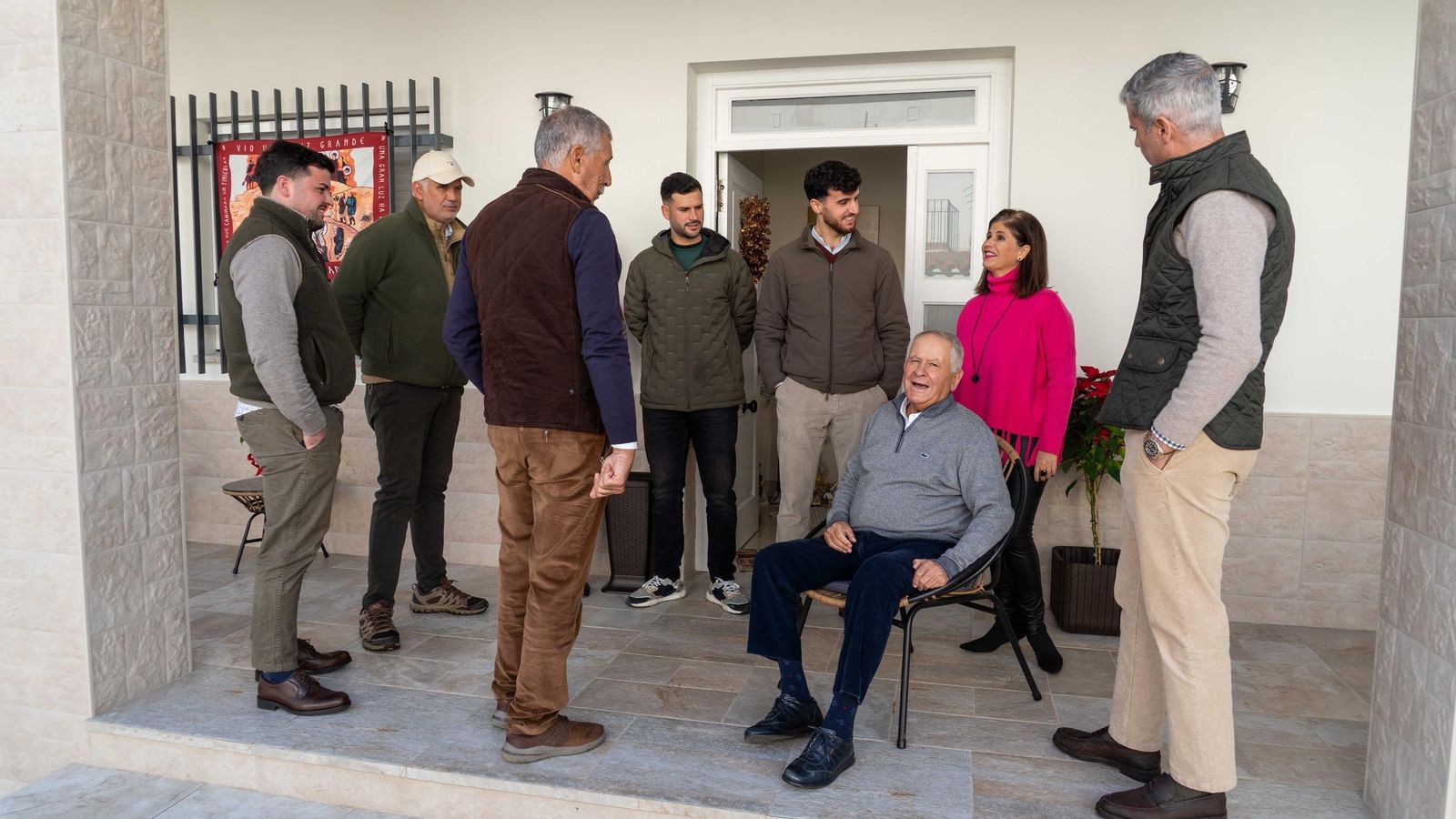 Pedro Bomba, sentado en la silla, conversa con su familia desde el patio de su casa en la Sierra.