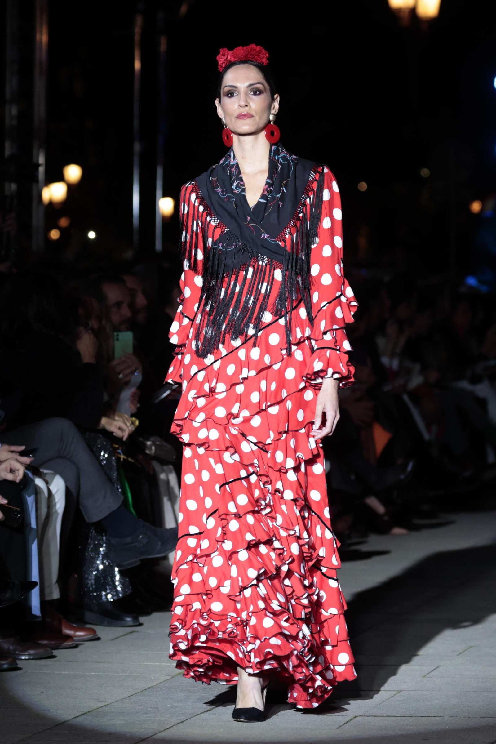 Traje de flamenca rojo combinado con un mantoncillo negro visto en el desfile 'Andalucía es flamenca'. Traje de flamenca rojo combinado con un mantoncillo negro visto en el desfile 'Andalucía es flamenca'.