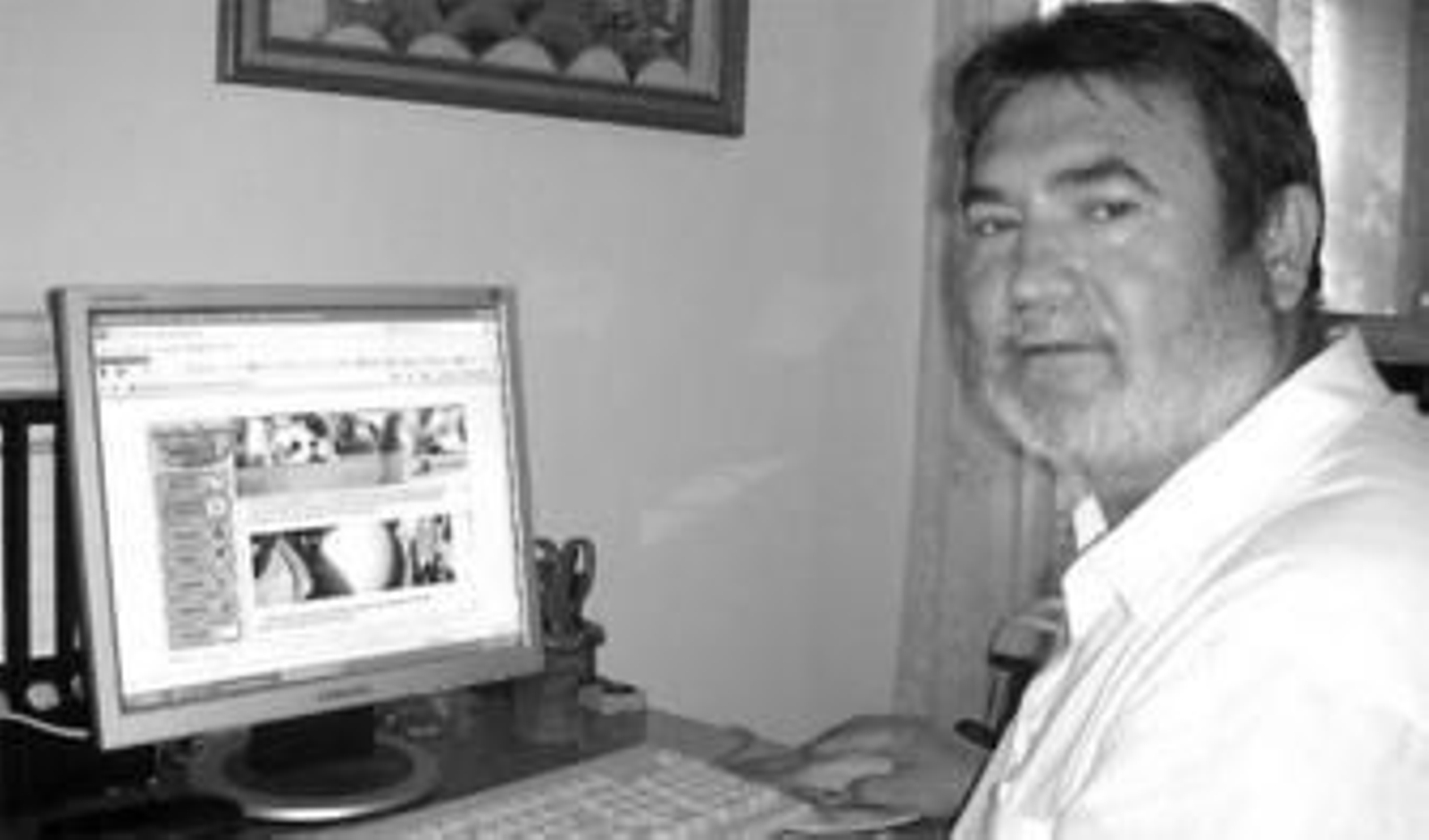 Bartolomé García, frente al ordenador donde gestiona la web 'www.naranjascoin.es'.