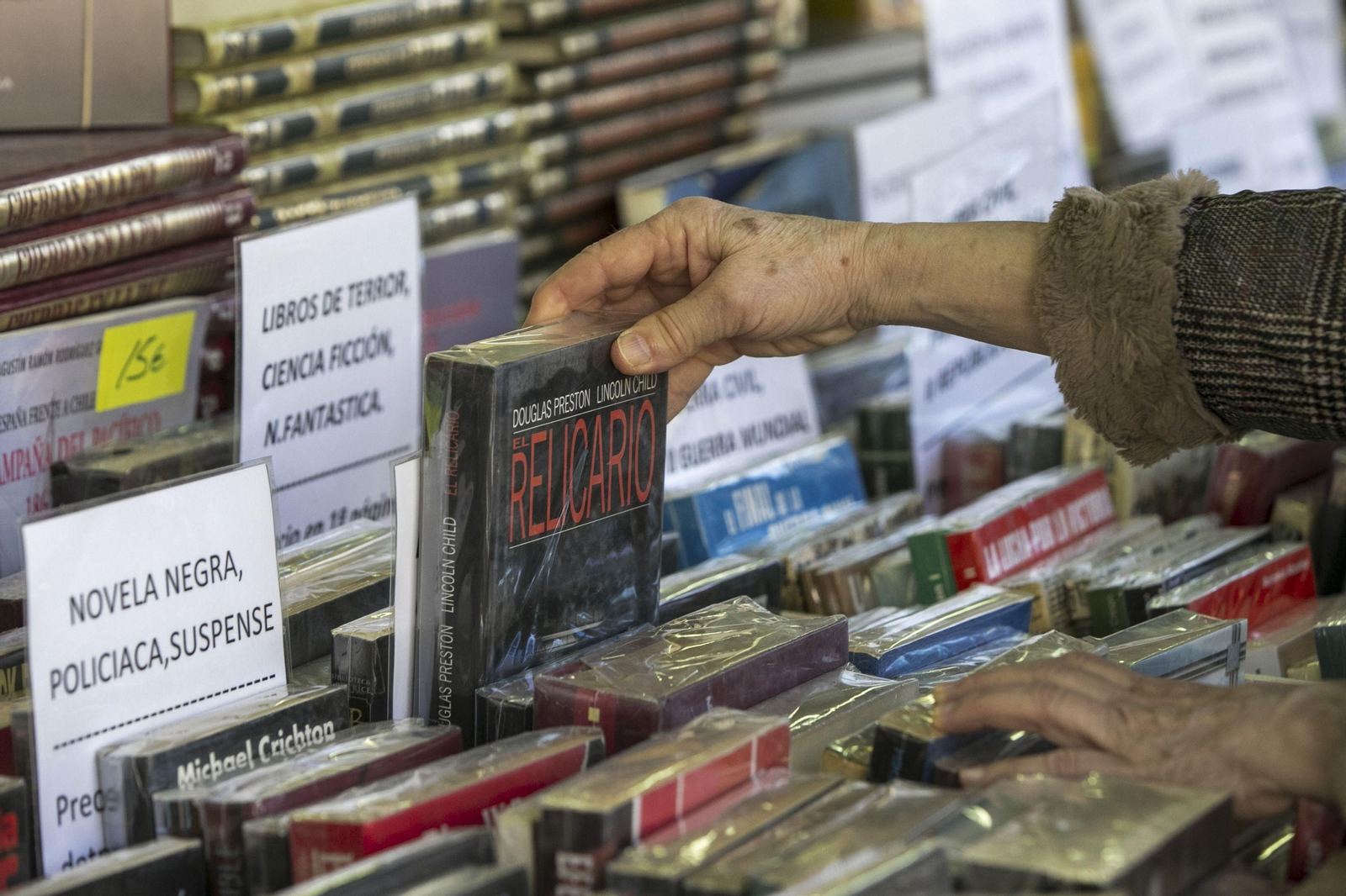 Una persona mira libros durante una feria.