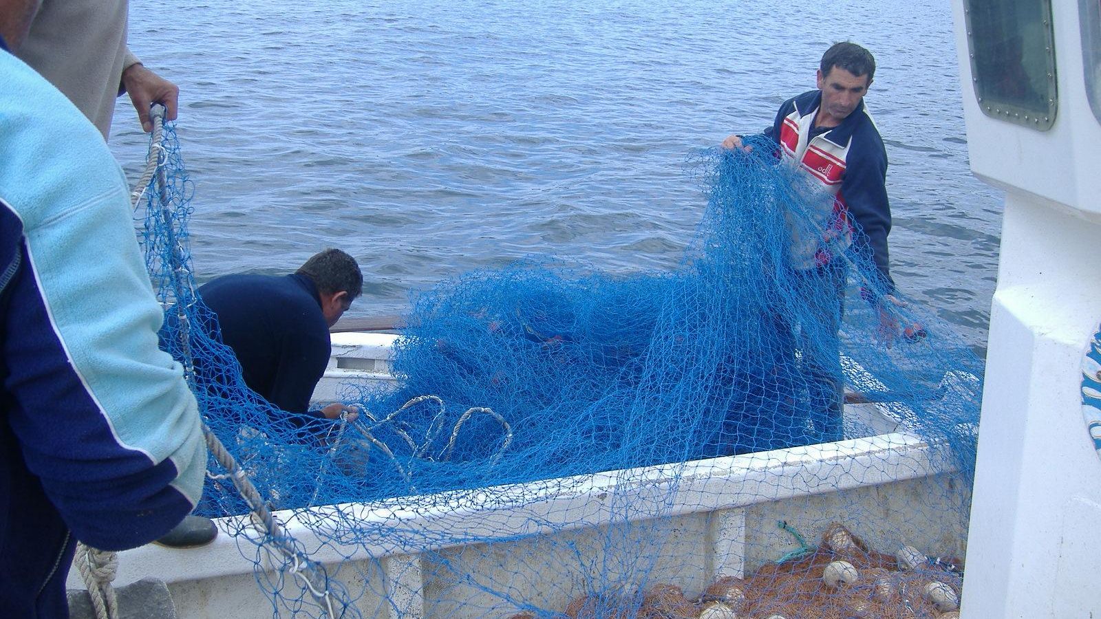Preparando la pared de red que será lanzada al mar.