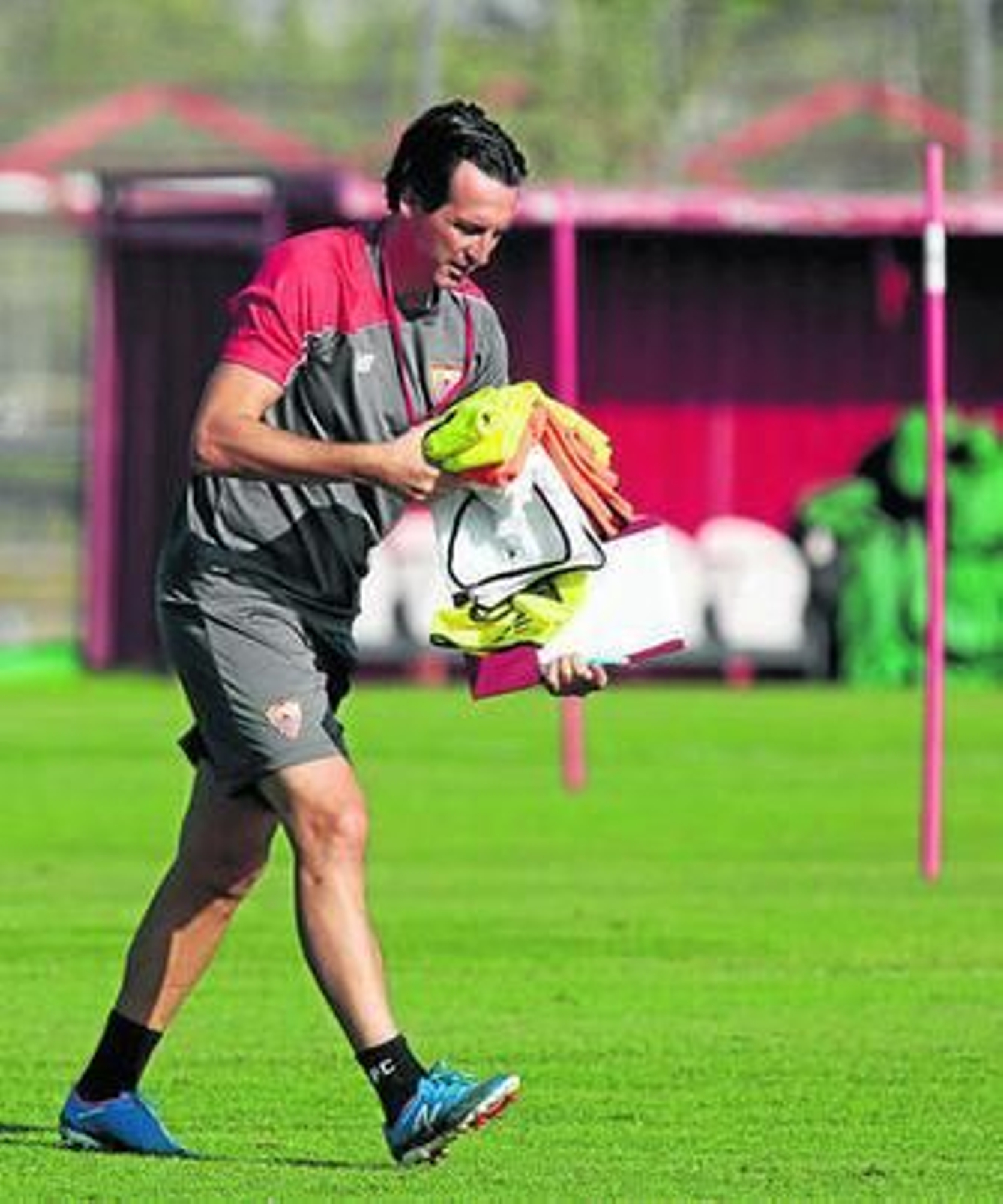 Unai Emery traslada unos petos con su inseparable carpeta.