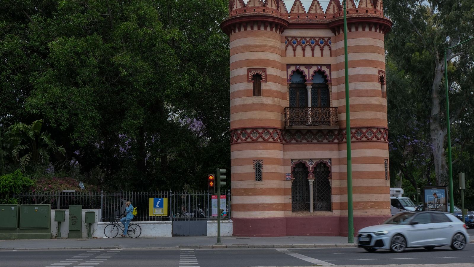 Un ciclista apoyado en la verja junto al Costurero de la Reina.