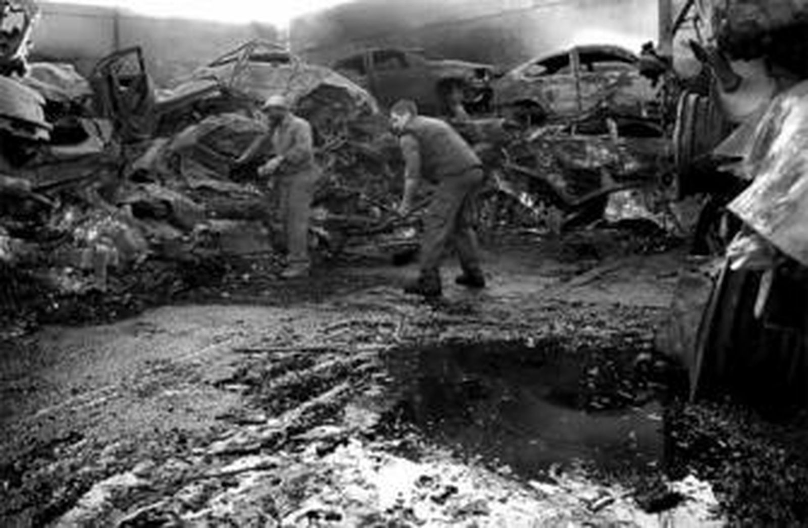 Varios operarios limpian la zona afectada por el incendio, ayer por la tarde.