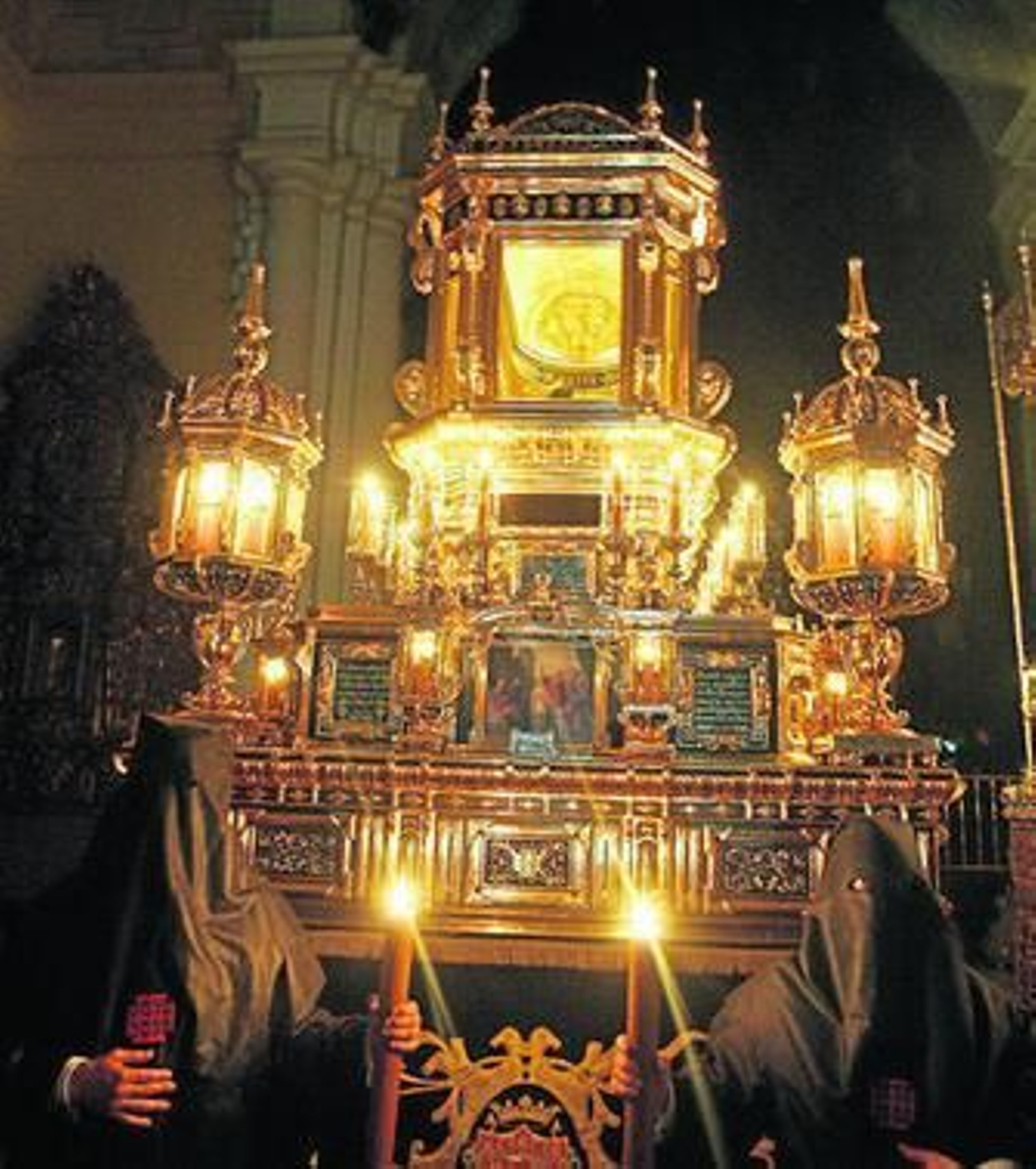 Unos penitentes alumbran el Santo Sepulcro, en la Compañía.