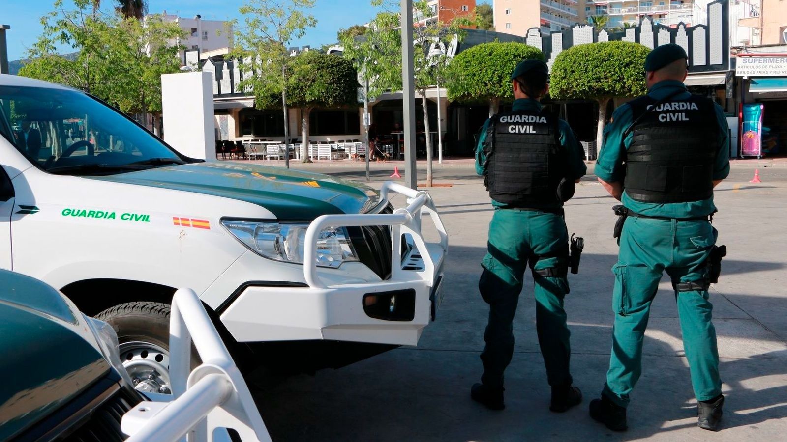 Agentes  de la Guardia  Civil  frente a unos coches patrulla.
