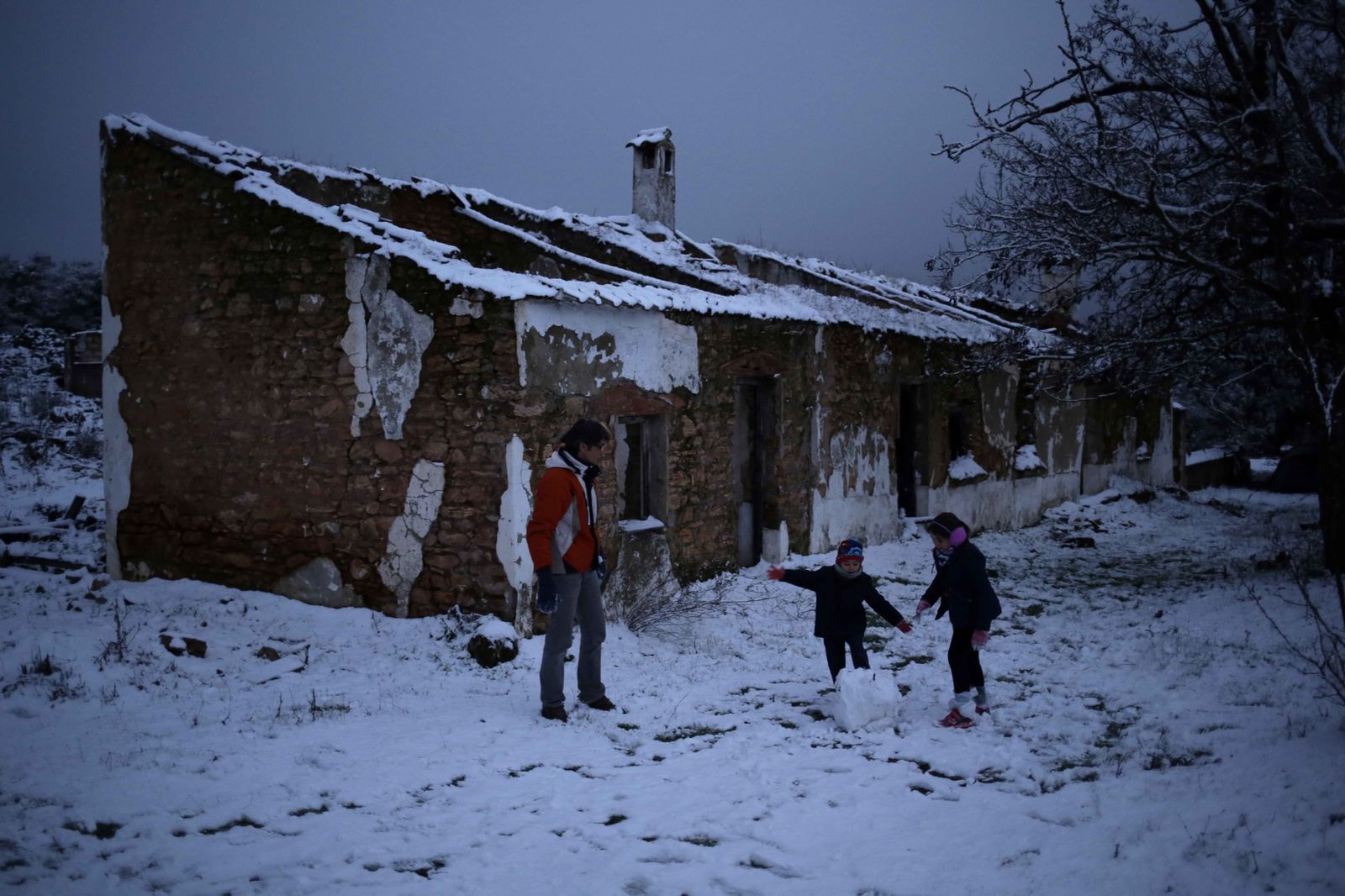 Una familia prepara una bola para construir un muñeco de nieve en El Saltillo.