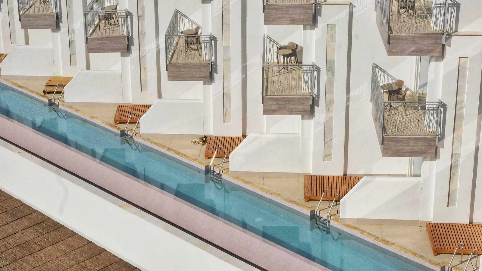 Línea de habitaciones con acceso directo a una alargada psicina. Línea de habitaciones con acceso directo a una alargada psicina.