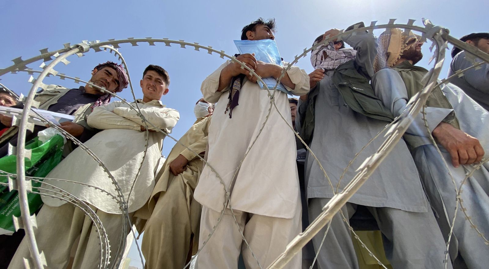 Afganos esperan en las afueras del aeropuerto de Kabul para intentar abandonar el país tras la llegada de los talibanes.