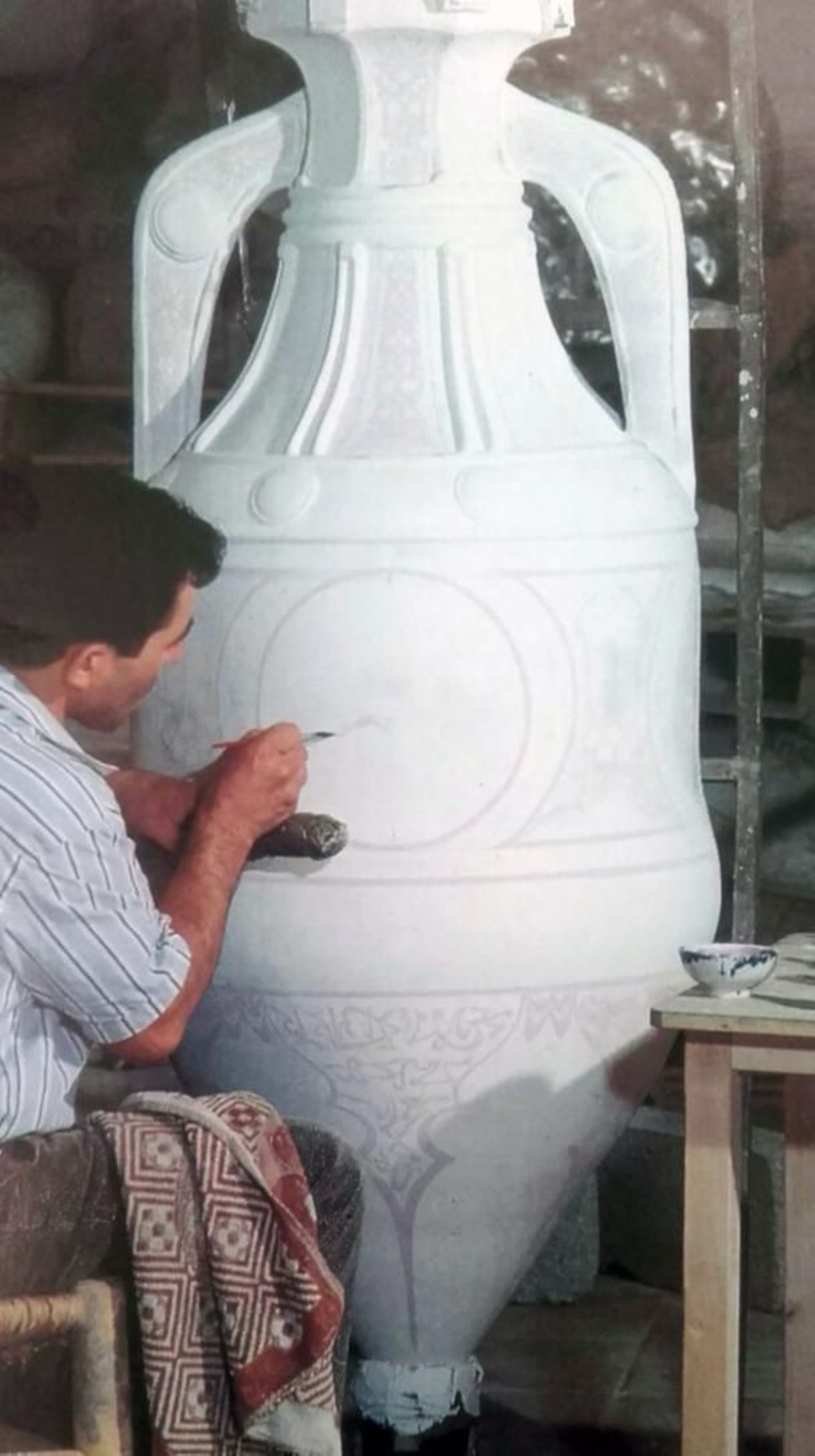 Con uno de los jarrones.