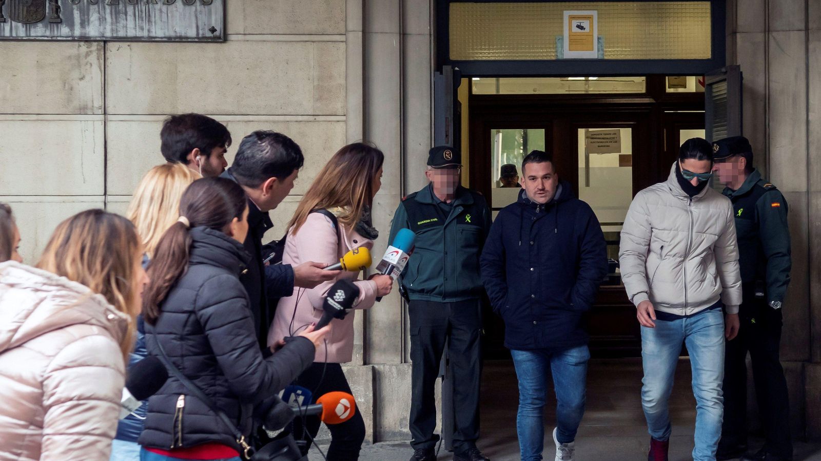 Dos miembros de la Manada salen del juzgado.