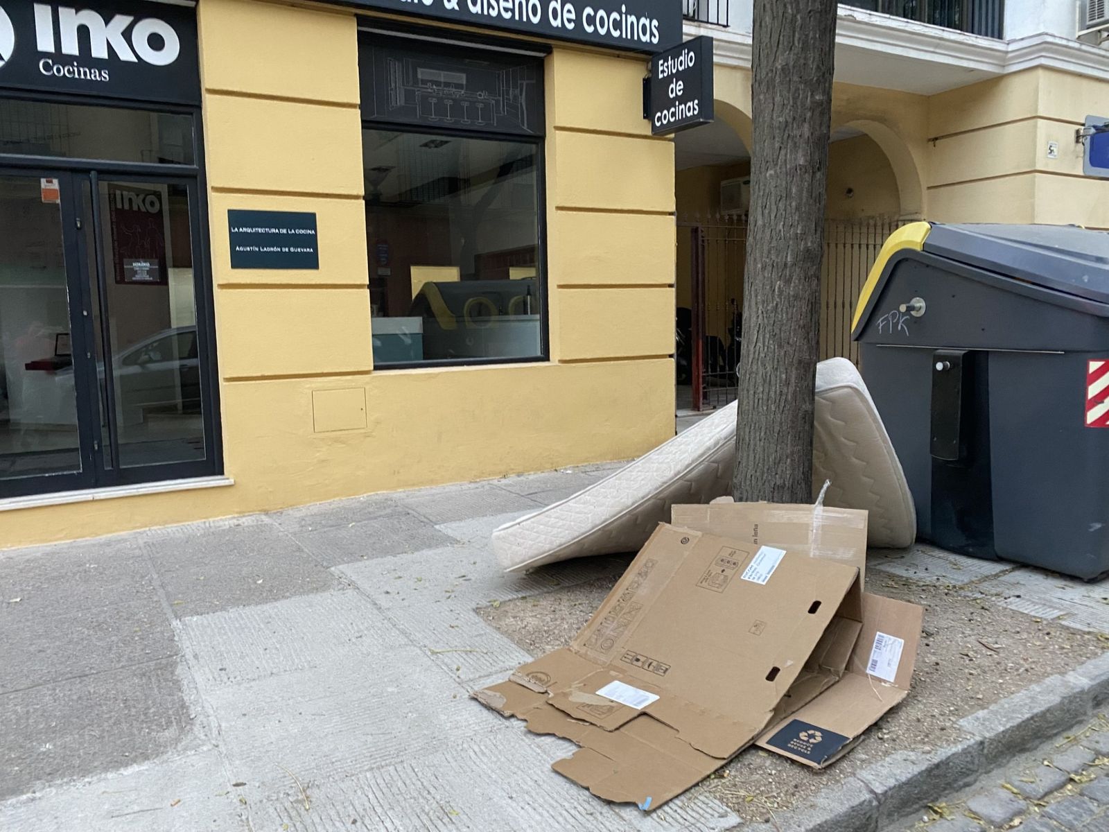 Los contenedores de basura en la calle Santo Domingo con el colchón y los cartones