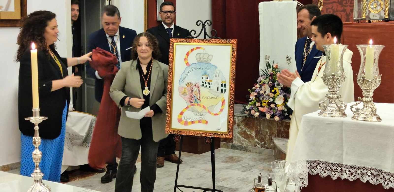 Lola Coca junto al cartel del Grupo Joven de Emigrantes.