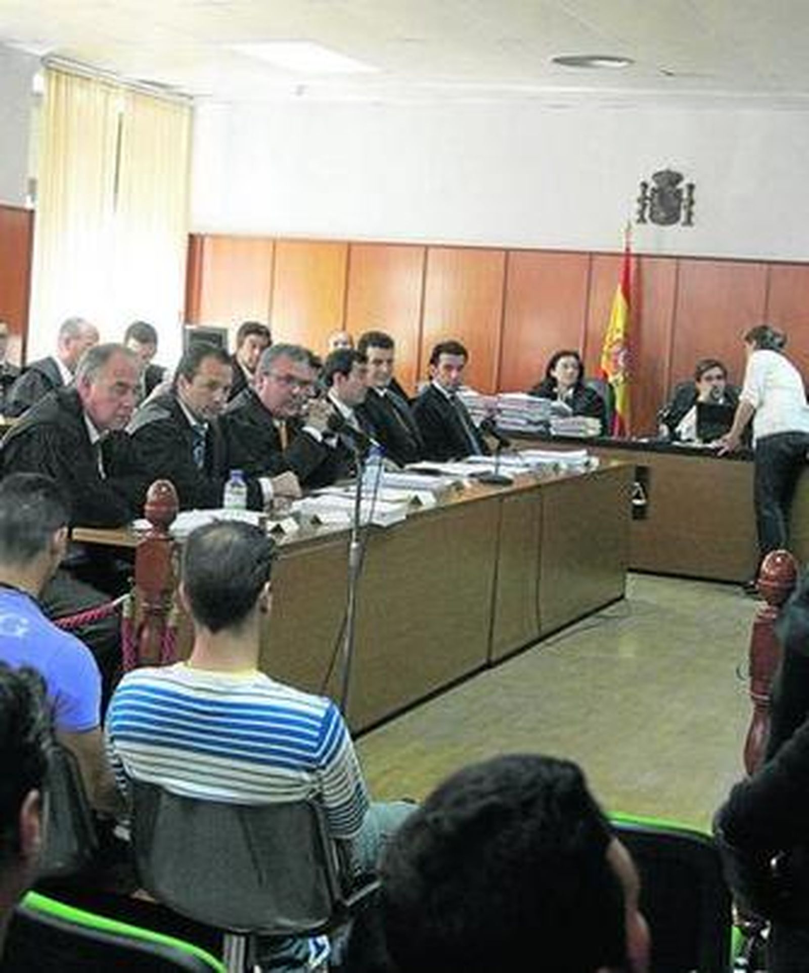 Acusados, de espaldas, y algunos abogados durante el juicio.