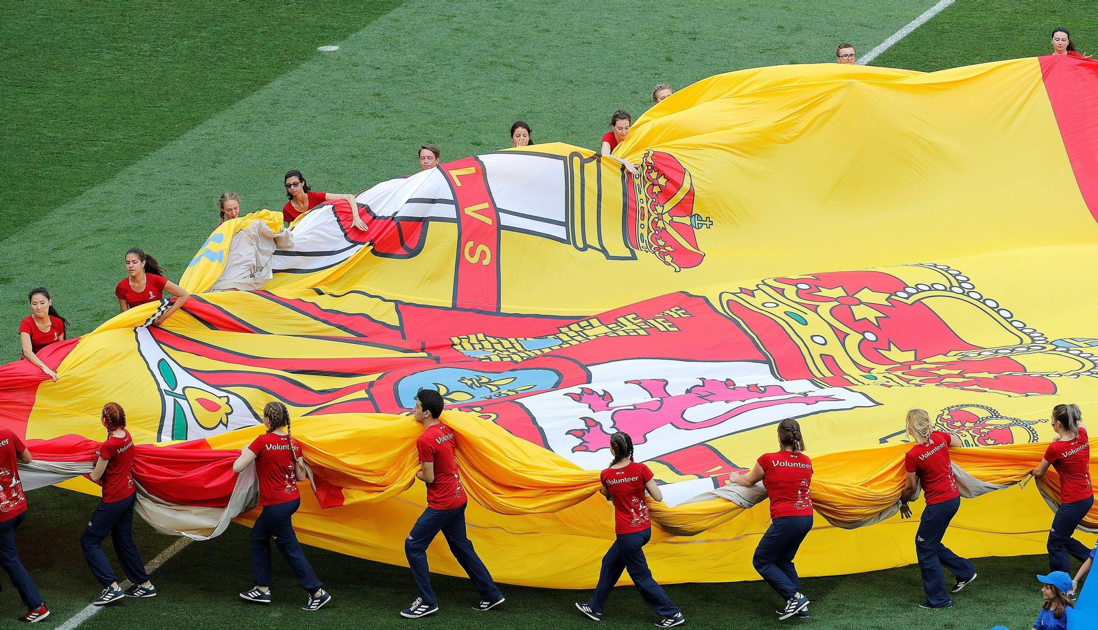Voluntarios llevan la bandera de España en un Mundial.