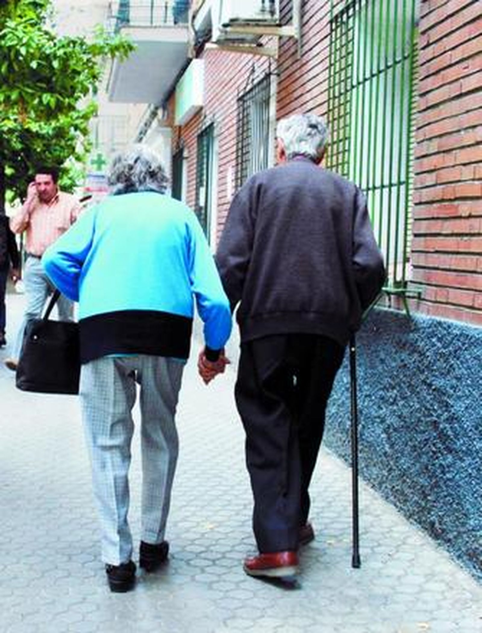 Una pareja de ancianos camina por la calle.