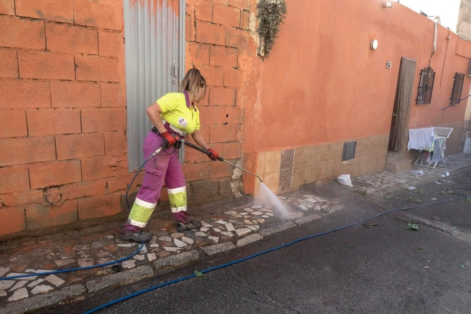 Una operaria baldea una calle del casco histórico de Almería