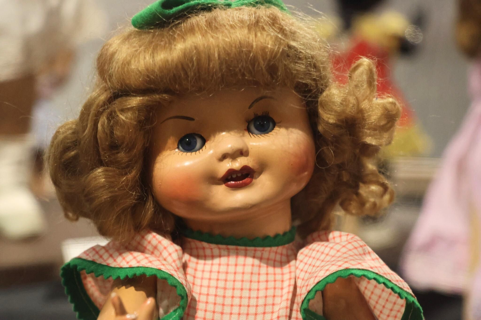 Detalle de muñeca con rizos y vestido a cuadros, que muestra la transición hacia diseños más elaborados y expresivos en la muñeca española.