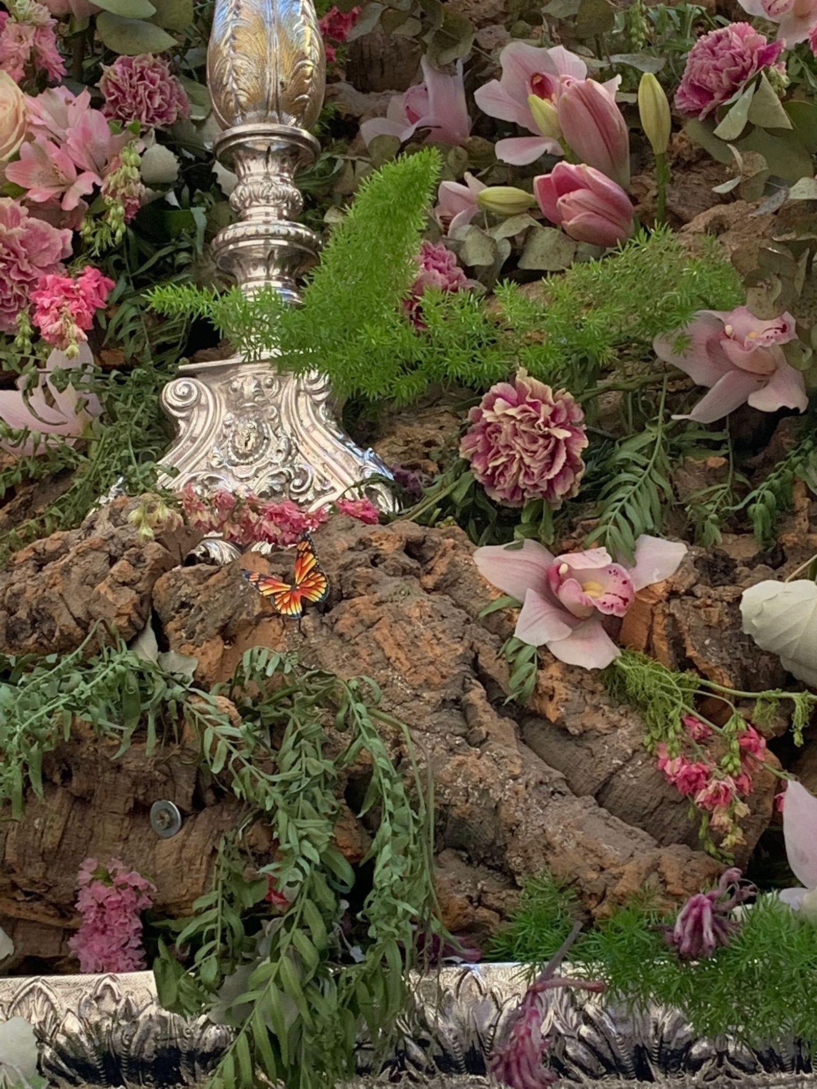 Una mariposa entre las flores del paso de la Divina Pastora