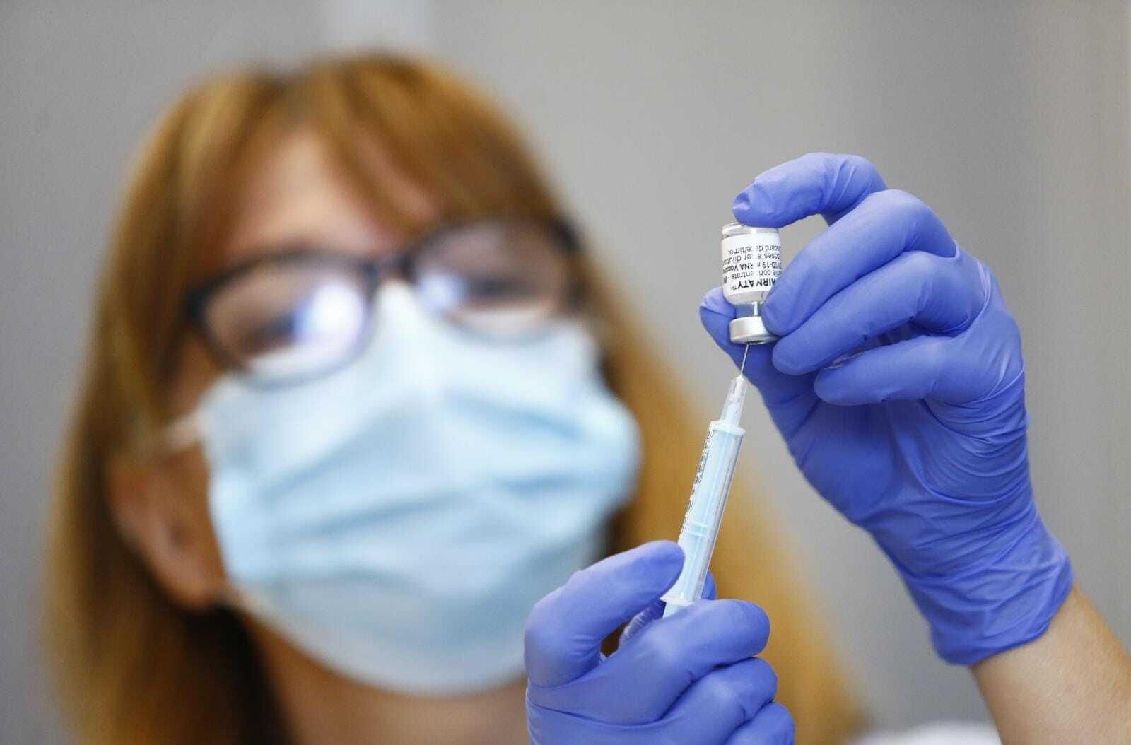 Una sanitaria sostiene una vacuna contra el Covid