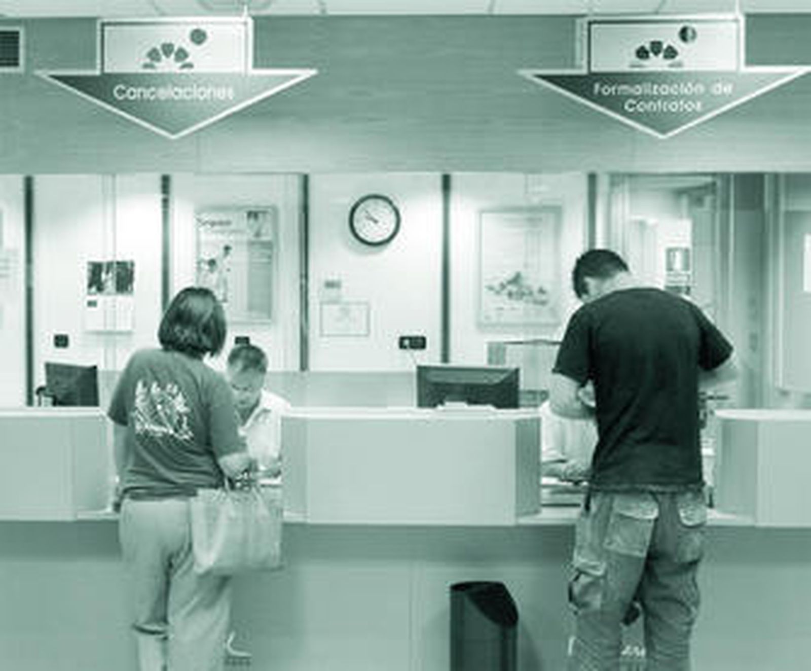 Dos usuarios de una entidad financiera arreglan sus asuntos en una oficina.