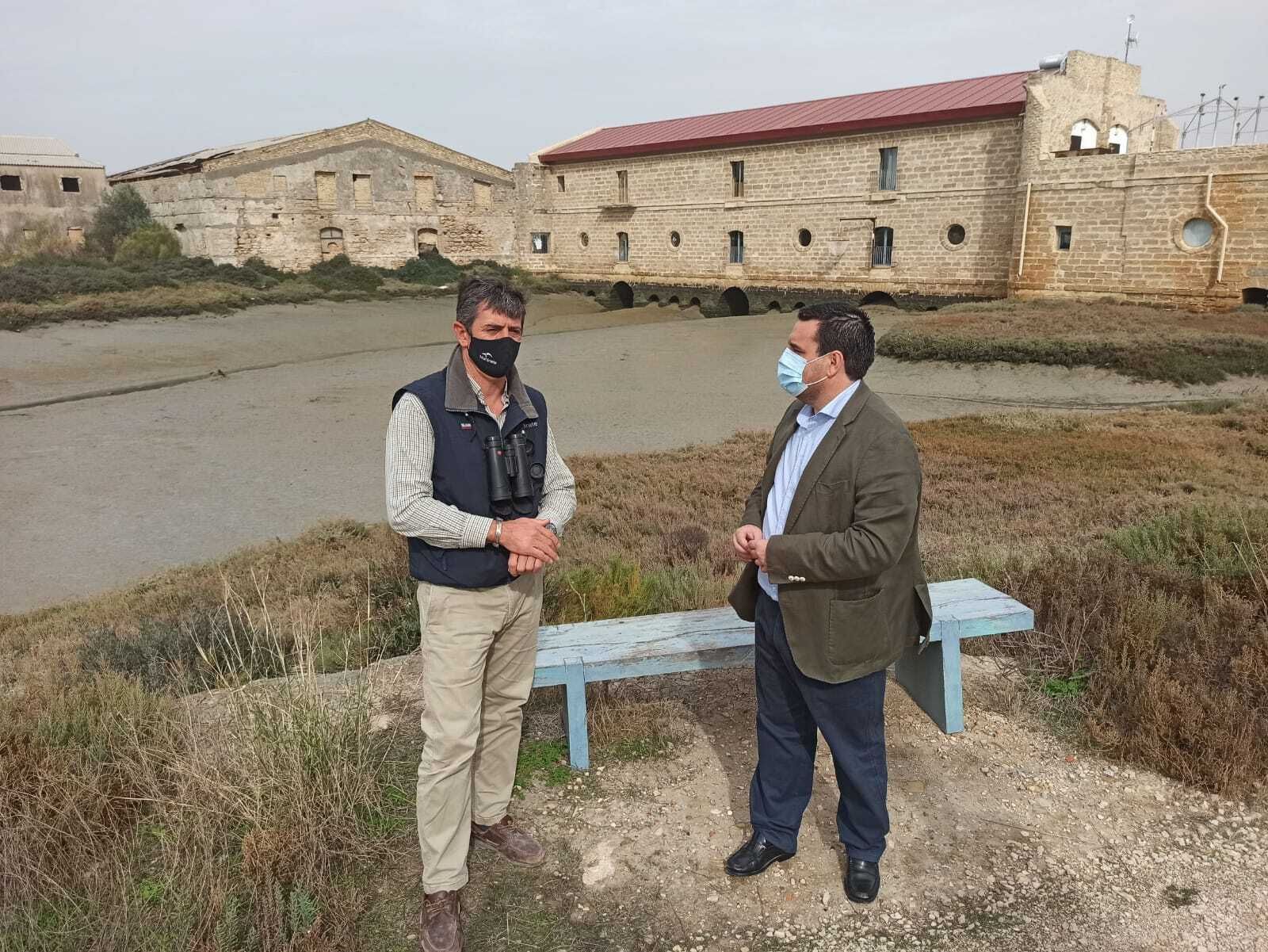 El concejal de Turismo, con Juan Martín ante el molino de mareas.