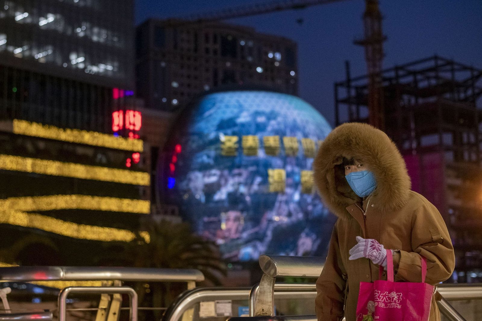 Una mujer se protege con una mascarilla en el centro financiero de Shanghái.