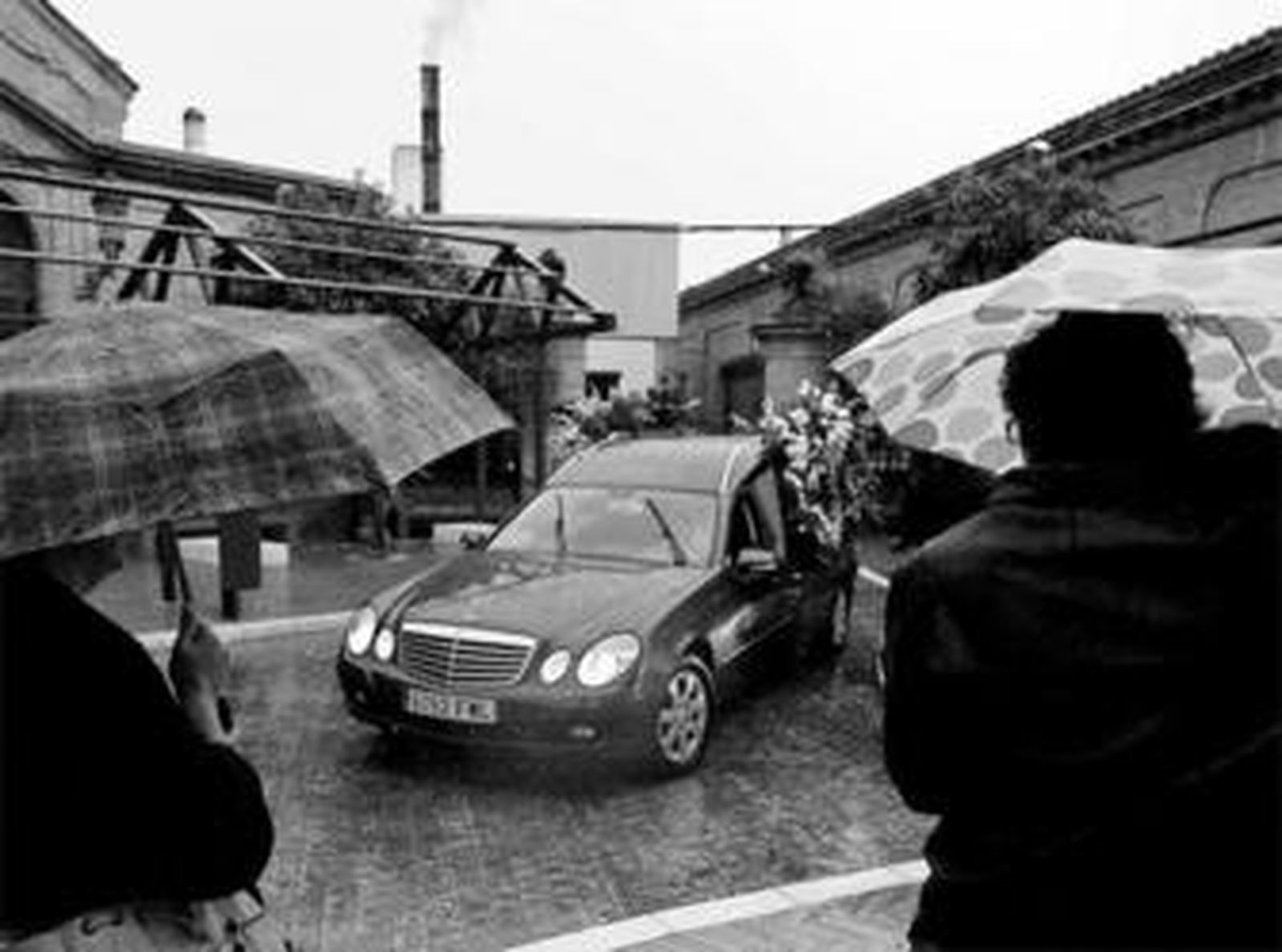 Familiares y amigos de Mario Maya observan ayer la llegada del coche fúnebre al cementerio de Sevilla.