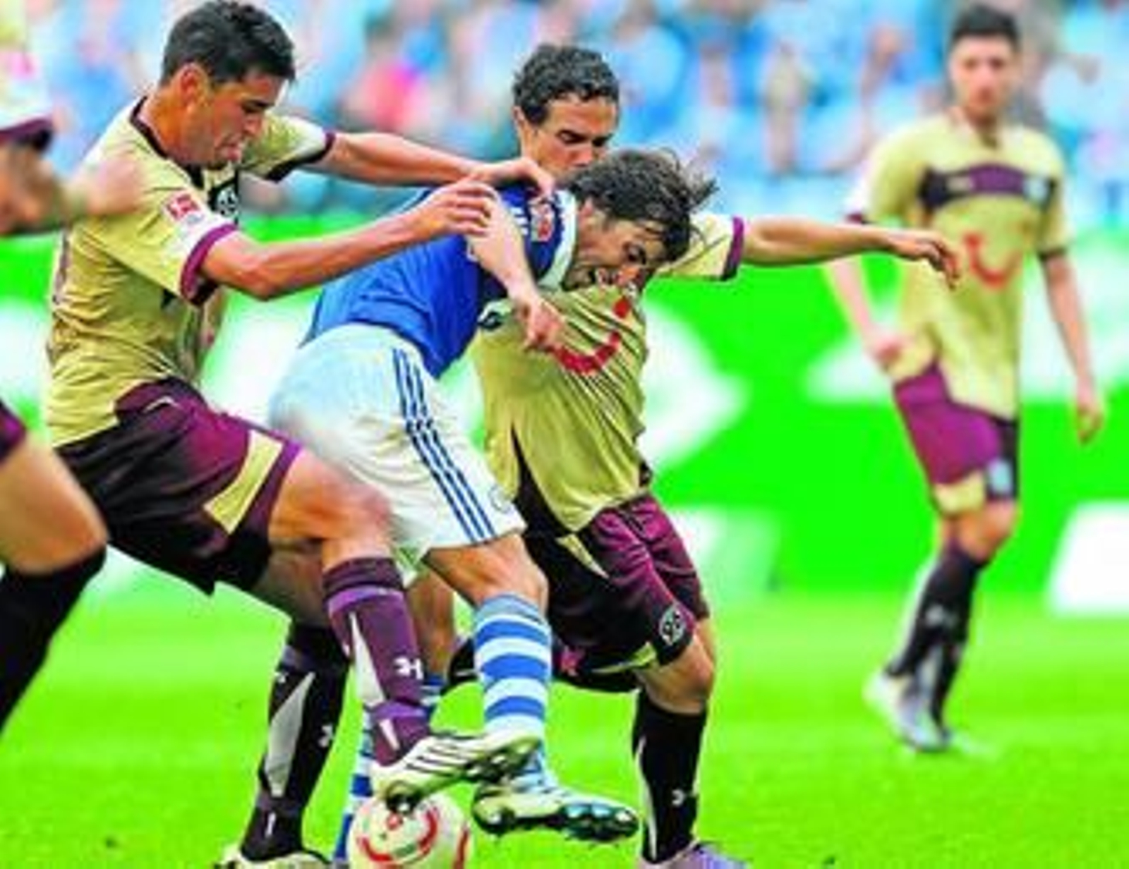 El jugador del Hannover Haggui trata de robar el balón a Raúl en un duelo ante el Schalke.