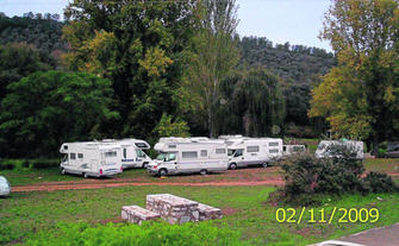 Siete autocaravanas aparcadas el puente de Tosantos en la explanada junto a la Ribera del Múrtigas.
