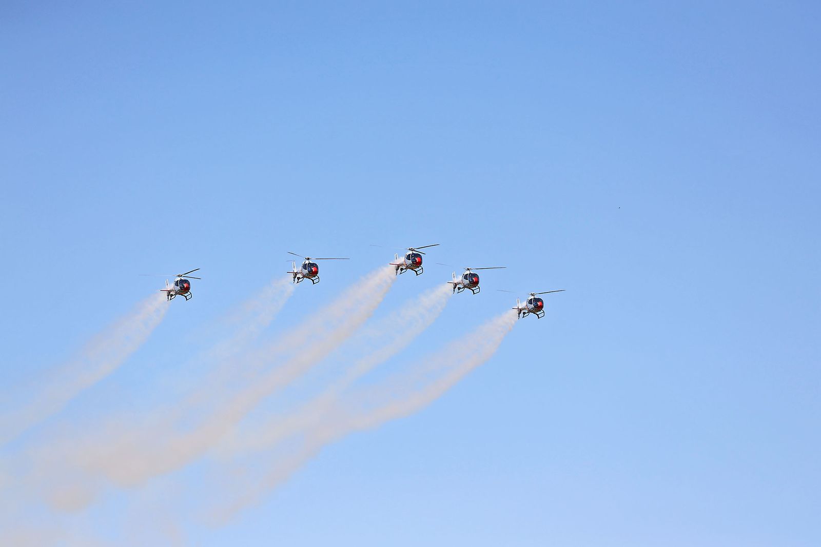 Fotografías de la exhibición aérea de la Patrulla Acrobática de Paracaidismo del Ejército del Aire 'Papea' y de la Patrulla Acrobática de Helicópteros 'ASPA'  en los actos de homenaje al centenario del Plus Ultra presidido por S.M. el Rey Felipe VI