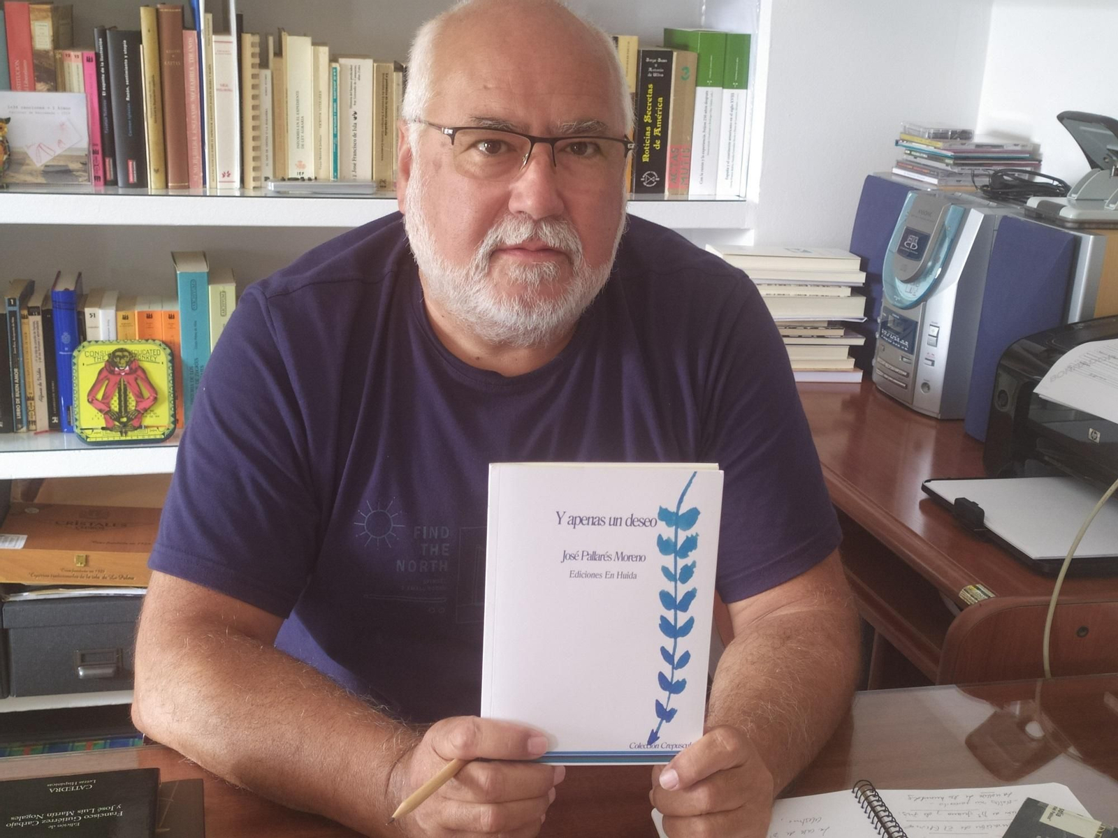 El poeta José Pallarés Moreno mostrando un ejemplar de su cuarto libro, titulado 'Y apenas un deseo'.