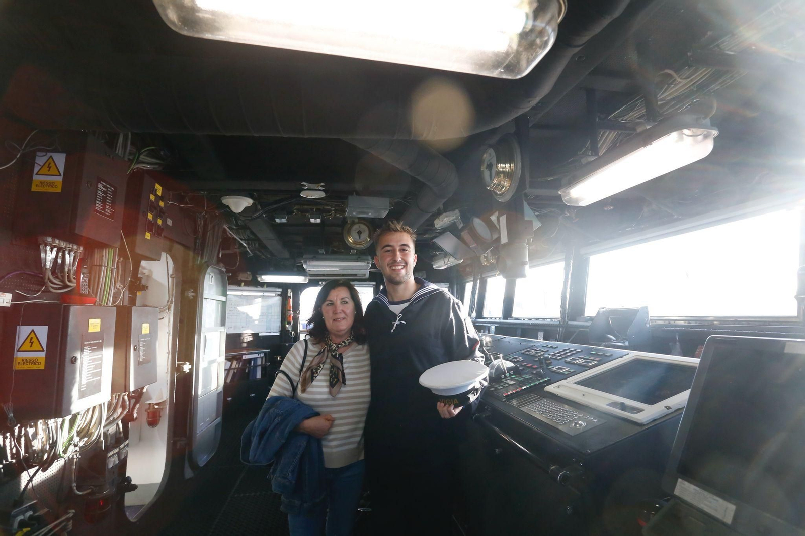 Una mujer se fotografía junto a uno de los tripulantes del 'Vigía' en el puente de mandos.