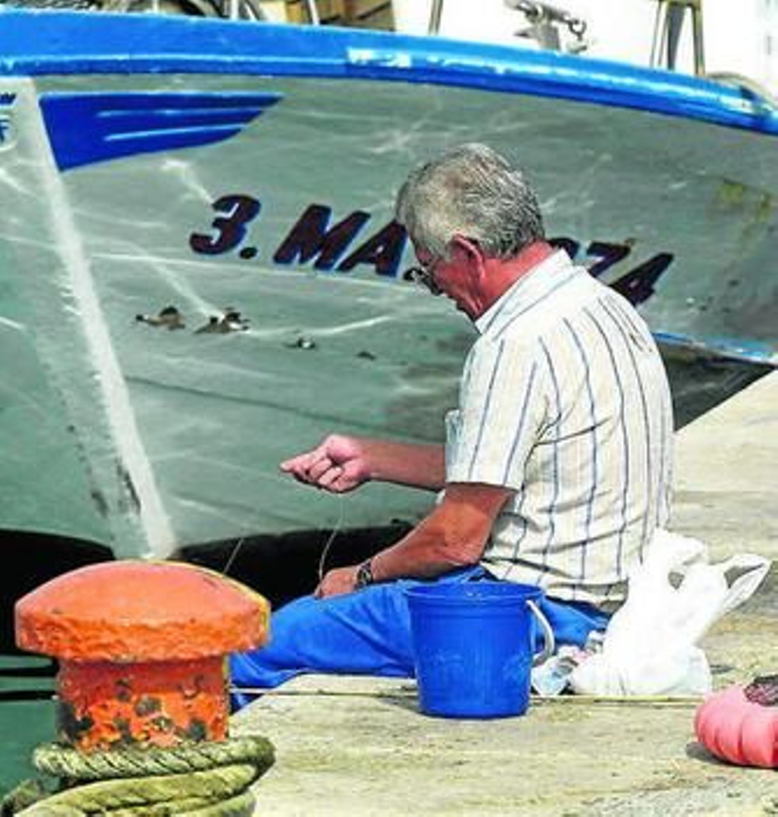 Un pescador cose una red.