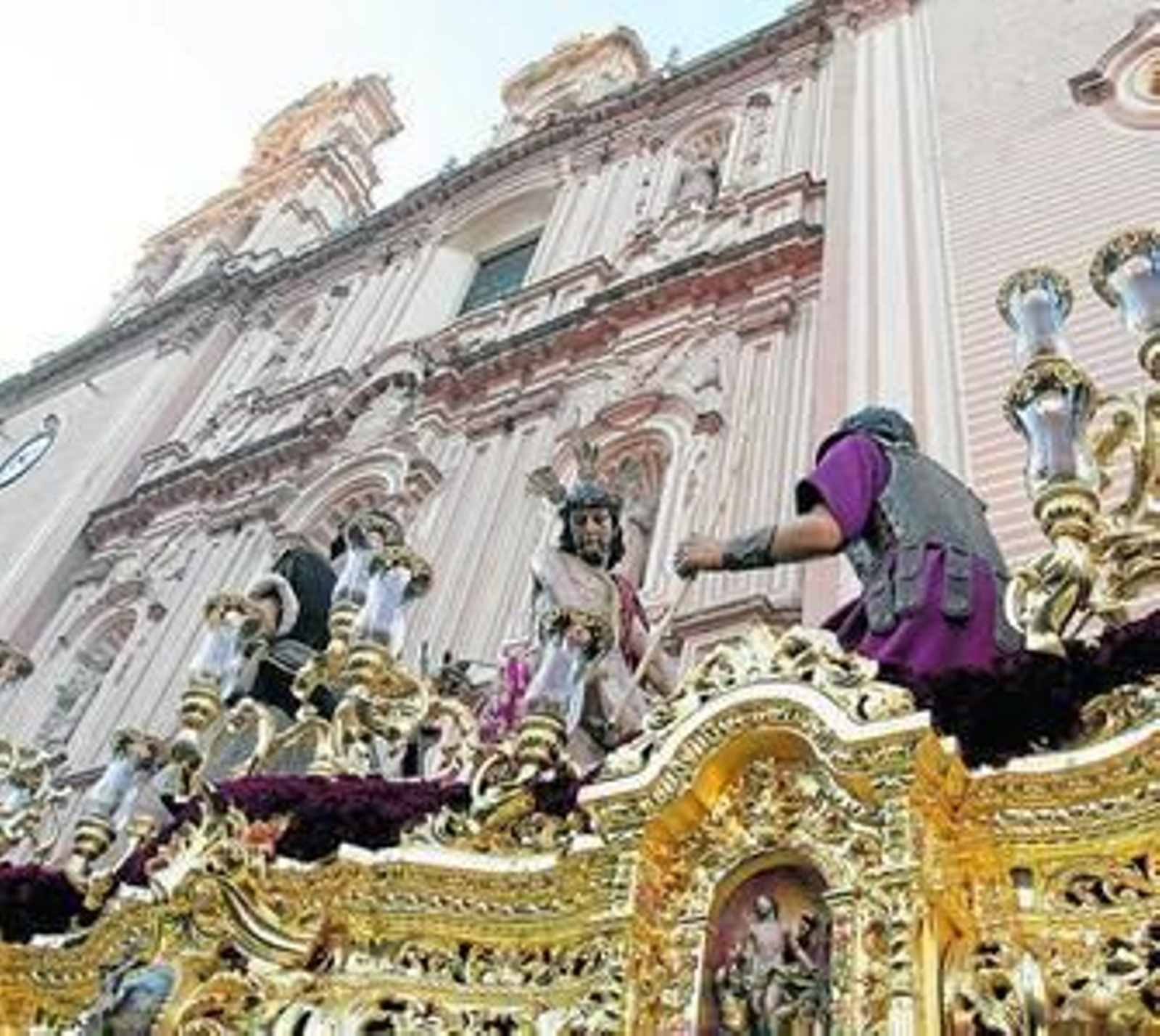 El paso de Jesús de las Cadenas con el fondo de la Santa Iglesia Catedral a su salida. A la derecha, una mujer contempla desde un balcón de la Universidad el paso del Buen Viaje.
