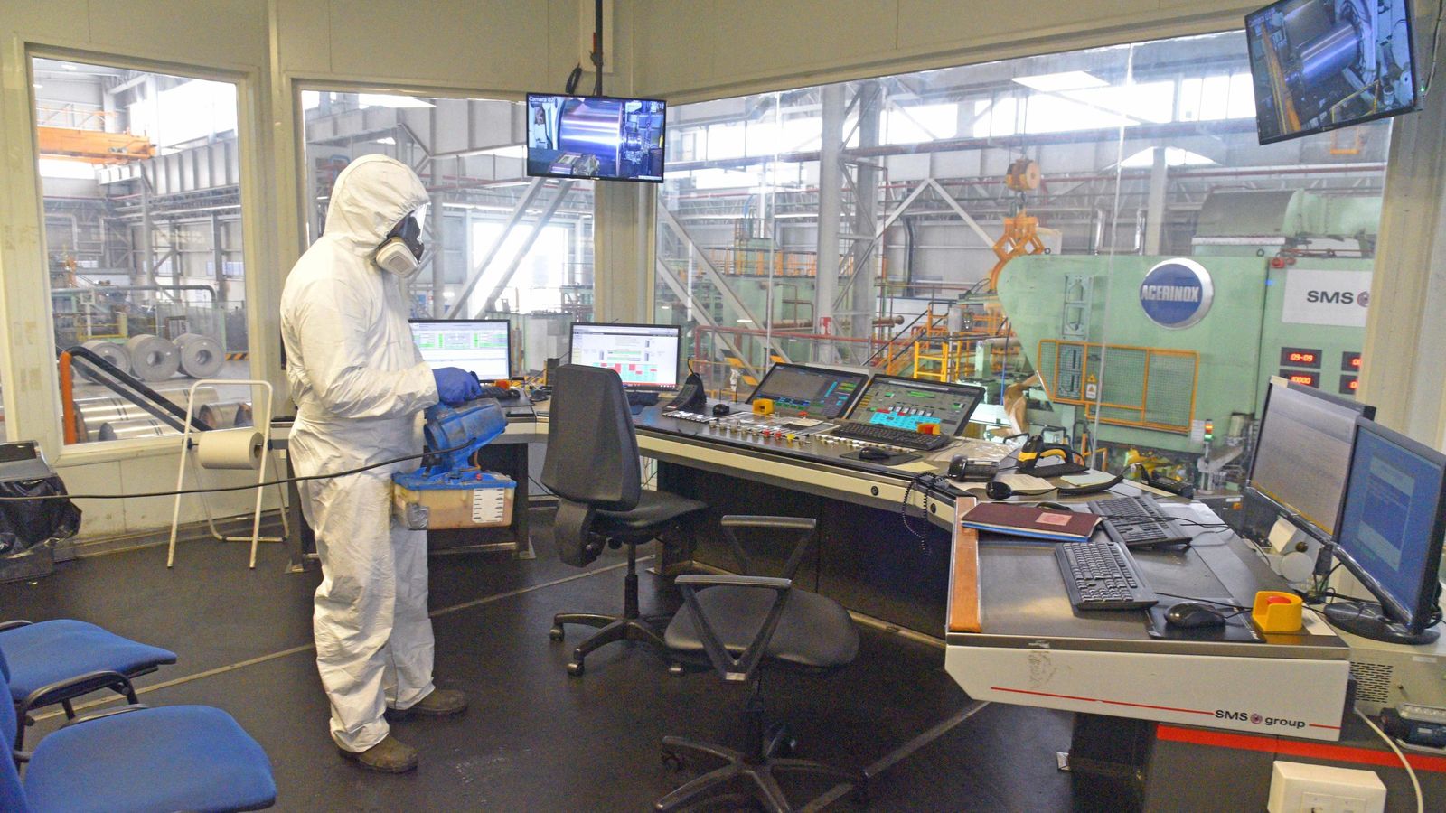 Una persona desinfecta un panel de mandos en la factoría de Acerinox Europa.