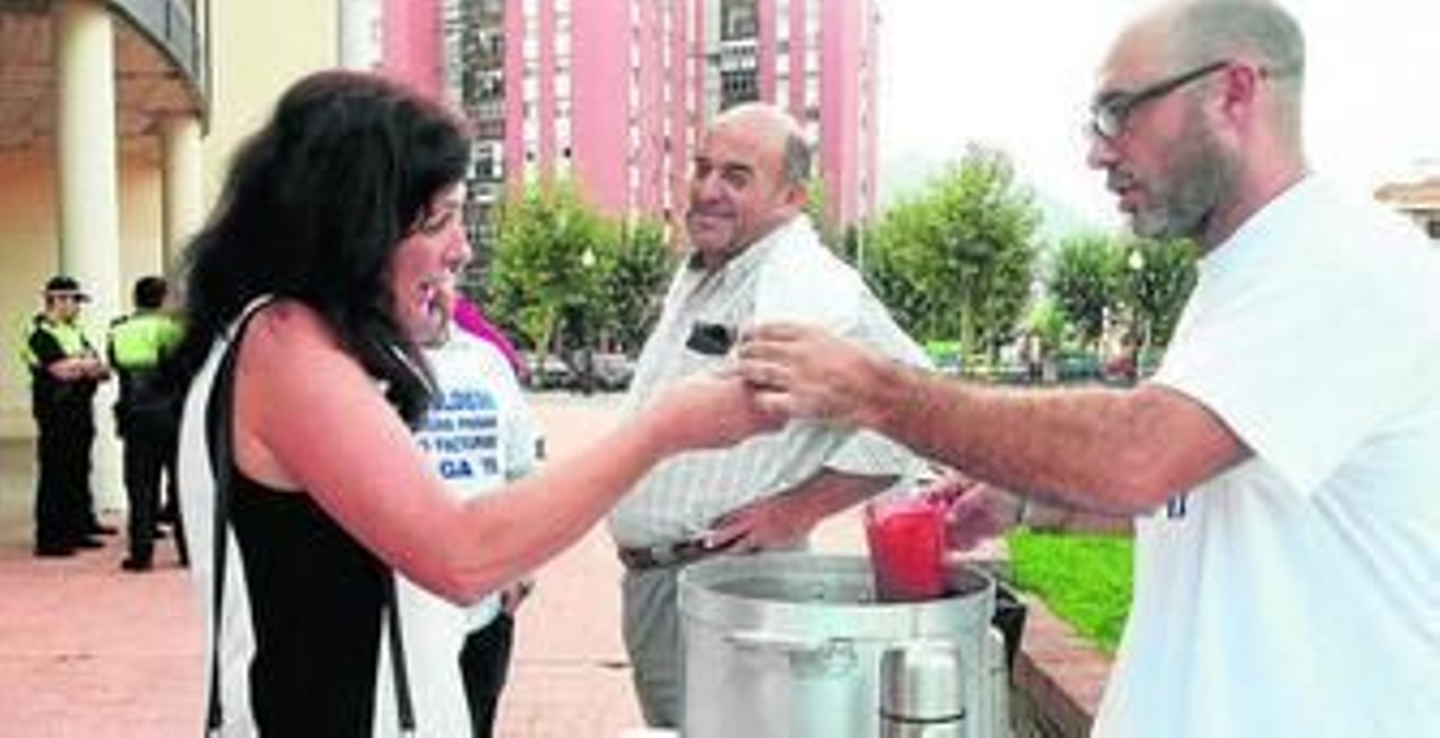 Una trabajadora recibe su vaso de chocolate de manos de uno de los organizadores.