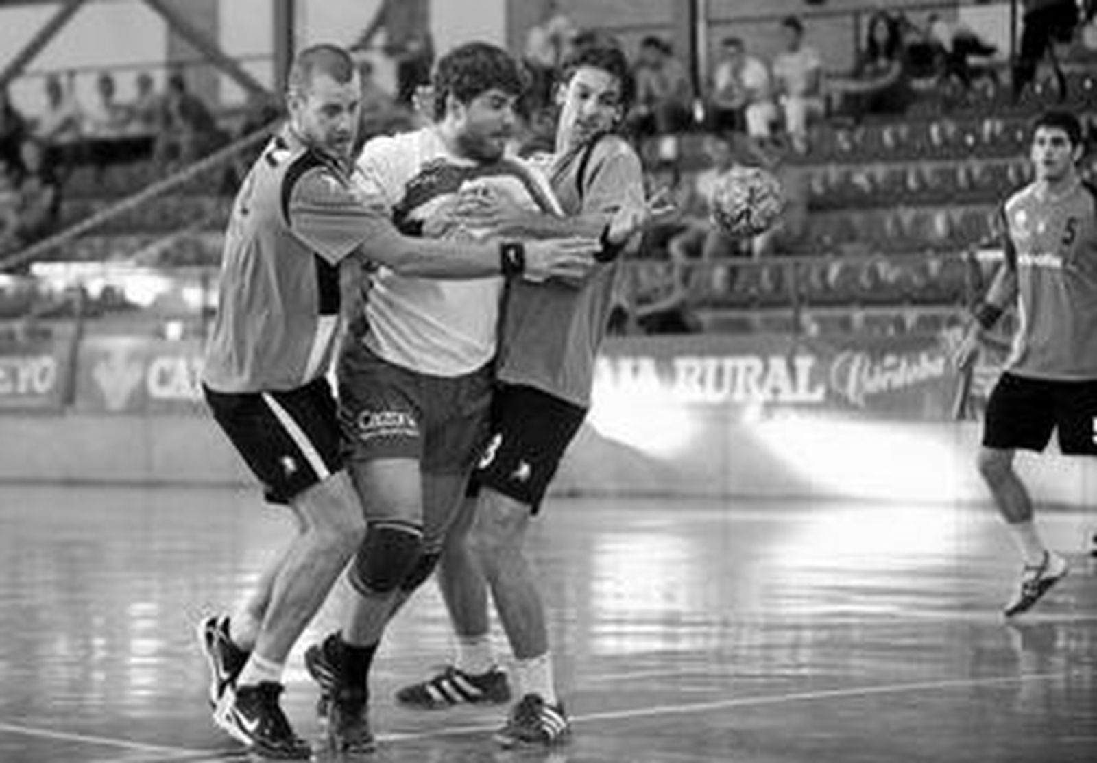 Quino Soler, del Prasa, trata de disparar agobiado por dos contrarios.