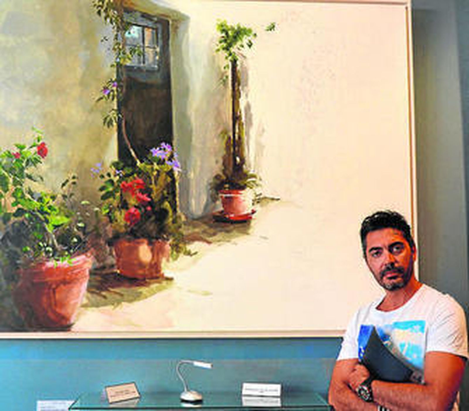 El pintor Juan Galán, junto a una de las obras de su exposición.