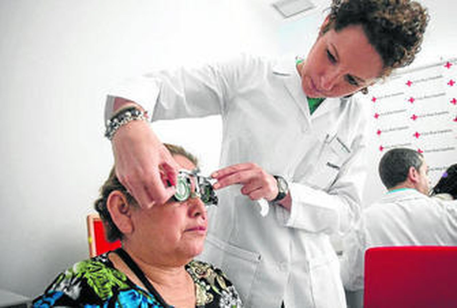 Una trabajadora de Multiópticas gradúa la vista a una mujer.