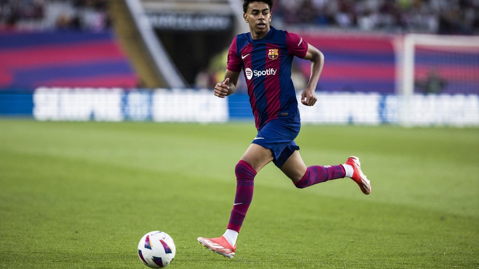 Lamine Yamal domina el balón con la cabeza levantada en un partido del Barcelona.