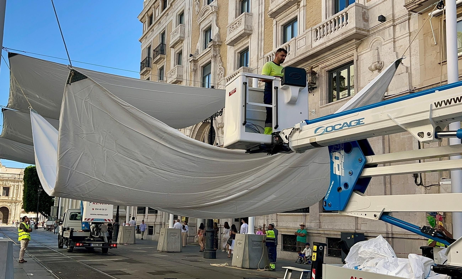 Los técnicos levantan una de las velas.