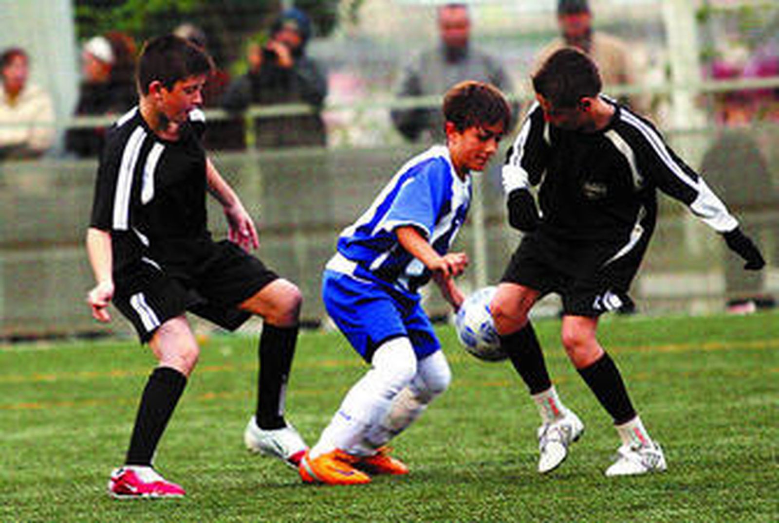 Un jugador del Málaga, rodeado por dos rivales del Cortijillo.