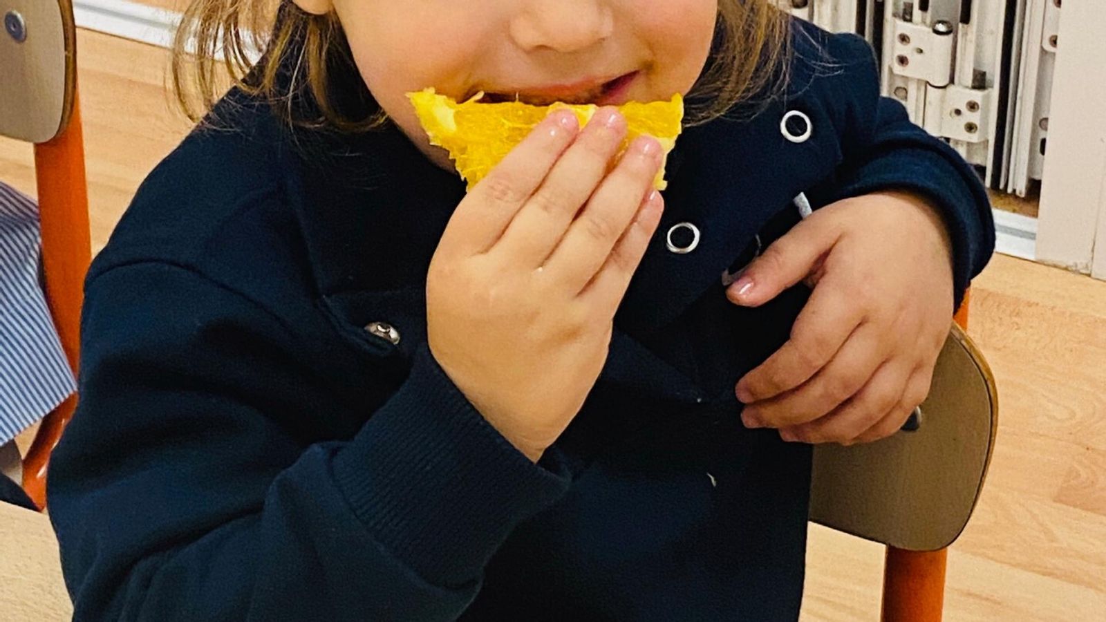 Niños aprendiendo a comer fruta desde pequeños.