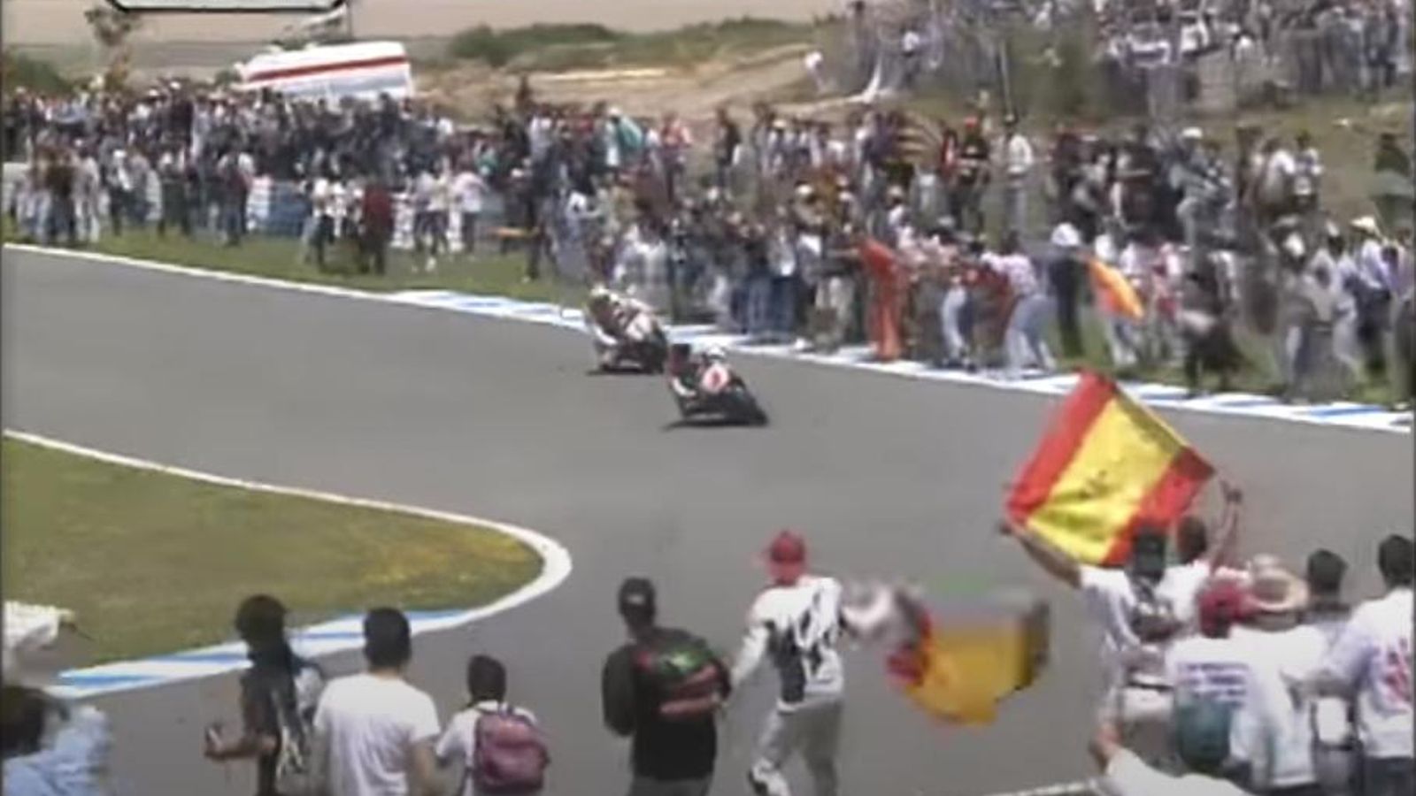 Crivillé, por delante de Doohan en la invasión de pista del público en 1996. Crivillé, por delante de Doohan en la invasión de pista del público en 1996.